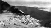 Centrum pevnosti Tobrúk v Libyi, město s přístavem na poloostrově ve Středozemním moři. Snímek vznikl po obsazení města Australany a Brity v lednu 1941. V přístavu ještě hoří zásoby nafty, zapálené před kapitulací Italy