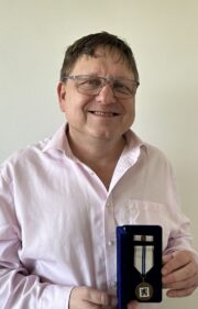 PhDr. Jiří Rajlich, Ph.D. s vyznamenáním.