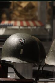 Průhled přes americkou helmu na vlajku vyrobenou ženami v Ostroměři na Královehradecku. Výstava "1945 - Voláme všechny Čehy!". FOTO Jiří Reichl, VHÚ Praha